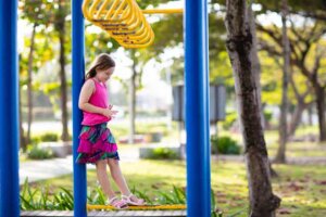 Parkta bir kız çocuğu yalnız başına düşünüyor yere bakıyor.